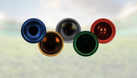 Five colored rings arranged in Olympic symbol pattern against blurred background.