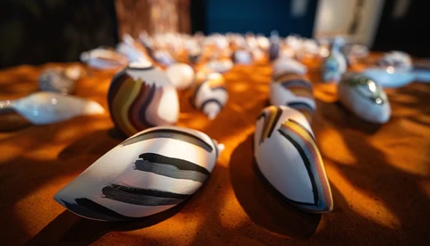 Multiple computer mice arranged on an orange surface with dramatic warm side lighting and soft shadows.