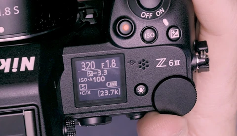Close-up of a Nikon Z6 III camera's rear LCD screen and control buttons displaying shooting settings.