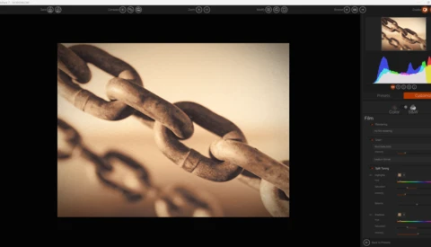 Close-up of rusted chain links with shallow depth of field and warm sepia toning.