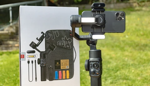 Smartphone gimbal with mounted phone and accessory kit displayed on white product card.