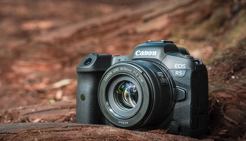 Canon EOS R5 mirrorless camera with RF mount lens on weathered wood surface.