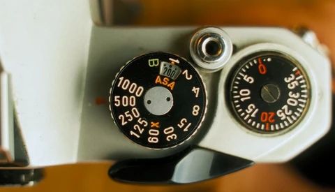 Vintage camera exposure meter dials with ASA settings and aperture values displayed.