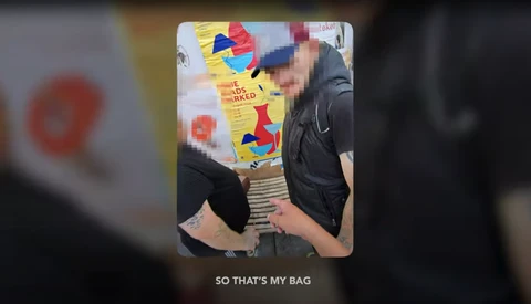 Person holding a colorful toy bag with pixelated graphics and text against a blurred background.