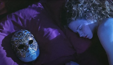 Ornate spherical object with intricate metalwork details held in hands against purple and blue ambient lighting.