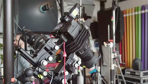 Professional cinema camera mounted on a rig with multiple lenses and accessories in a production studio.