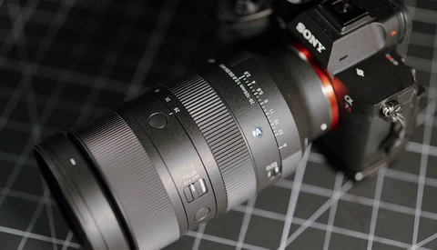 Sony mirrorless camera with attached telephoto zoom lens on a calibration chart surface.