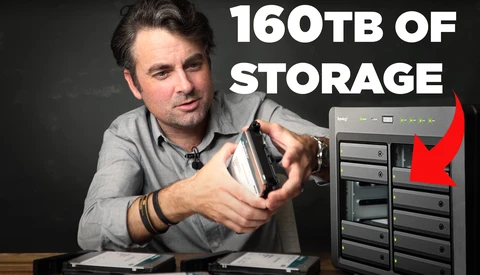 Man holding an external hard drive storage unit with multiple bays, displaying 160TB capacity text.