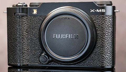 Fujifilm X-M5 mirrorless camera body with black textured grip and dark lens cap.