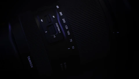 Close-up of camera lens markings and aperture settings in low light.