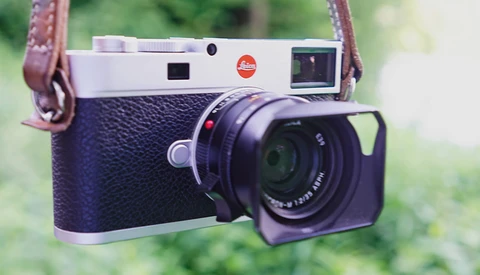 Leica M rangefinder camera with blue crocodile leather body and brown leather shoulder strap.
