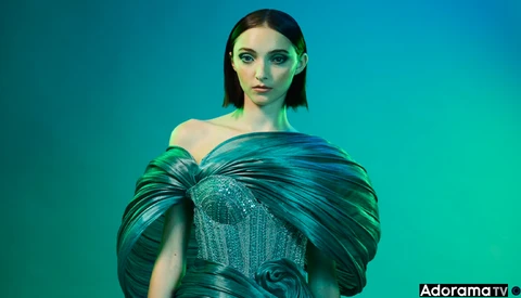 Woman in turquoise off-shoulder gown against monochromatic teal background.