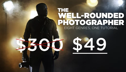 Photographer holding lighting equipment against dark background with studio lights.