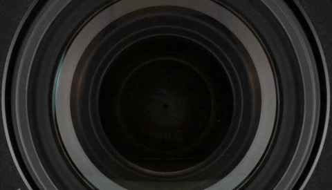 Concentric circular lens elements receding into darkness, showing internal optical glass geometry.