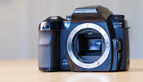 Konica Minolta Dynax 5 DSLR camera body with lens mount exposed, positioned against neutral background.