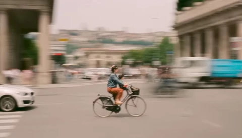 Cyclist riding through urban plaza with motion blur effect surrounding the figure.
