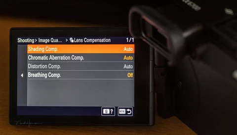 Screenshot of camera lens compensation settings menu showing shading, chromatic aberration, distortion, and breathing compensation options.