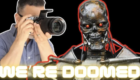 Photographer holding a DSLR camera next to a robotic skull with glowing red eyes and red accent lighting.