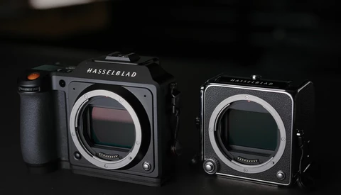 Two Hasselblad medium format cameras positioned side by side against a dark background.
