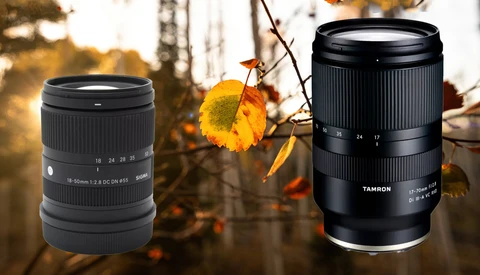 Two telephoto zoom lenses displayed against autumn foliage with golden backlighting.