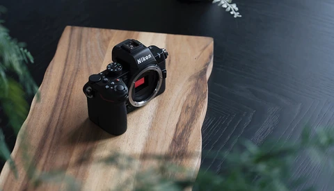 Nikon Z-series mirrorless camera body displayed on a wooden platform with natural window lighting.