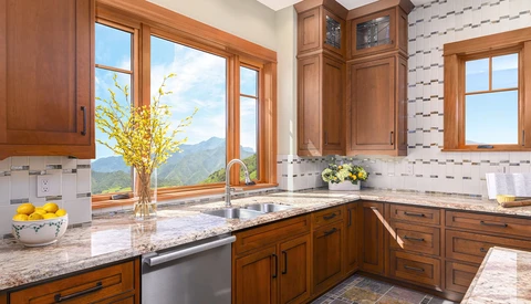 Luxury kitchen with wood cabinetry, granite countertops, and expansive windows overlooking mountains.