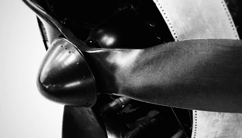 Close-up of aircraft propeller and engine cowling in black and white.