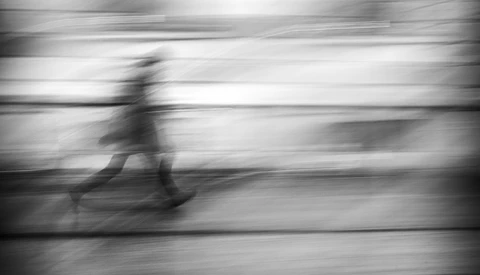 Blurred figure running at high speed with horizontal motion blur across frame.