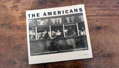 Cover of "The Americans" photography book by Robert Frank with introduction by Jack Kerouac, showing a black and white photograph of people on a bus.