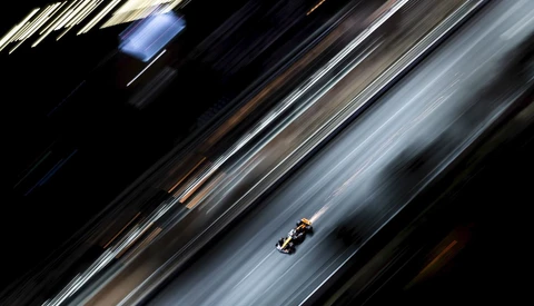 Formula One race car captured with motion blur on a diagonal asphalt track.