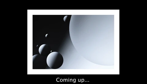 3D render of white spheres in graduated sizes arranged against dark and light curved surfaces.