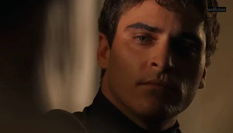 Man in dark clothing with dramatic side lighting against a blurred background.