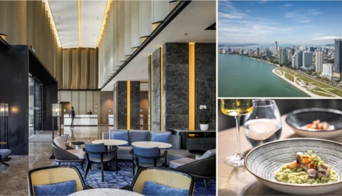Luxury hotel lobby with modern design featuring gold ceiling details, blue seating, and marble accents.