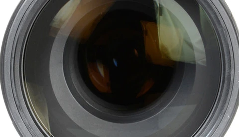 Close-up frontal view of a camera lens showing internal glass elements and aperture mechanism.