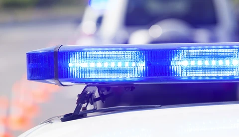 Blue LED emergency light bar mounted on a vehicle roof with bokeh background.