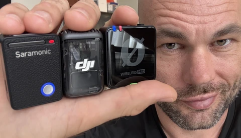 Man holding three wireless audio devices: a Saramonic recorder, DJI Mic transmitter, and Rode Wireless Pro receiver.