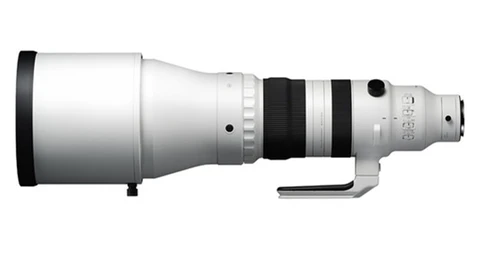 Illustration of a white telephoto lens with black accents and control rings shown in profile.