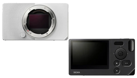 Comparison of two mirrorless camera bodies: a white compact model with exposed sensor mount on the left, and a black Sigma model with rear LCD screen and control buttons on the right.