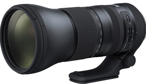 Black telephoto lens with tripod collar mounted on white background.