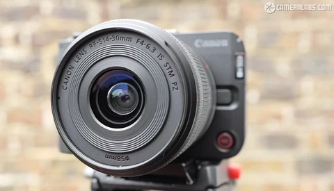 Canon EF-S 24mm f/2.8 STM lens mounted on a Canon mirrorless camera body against a brick wall backdrop.