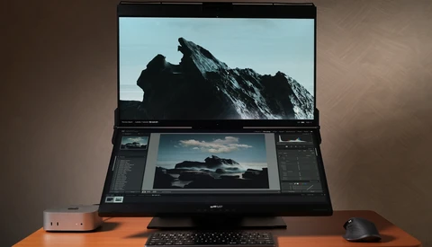 Laptop displaying mountain landscape photo with editing software panels open on secondary monitor.