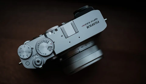 Top-down view of a silver rangefinder camera with manual dials and a black lens attached.
