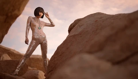 Woman in beaded bodysuit posing on desert rock formations under dramatic sky.
