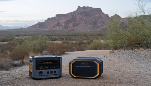 Two portable power station units positioned on desert ground with mountains and desert vegetation in background.