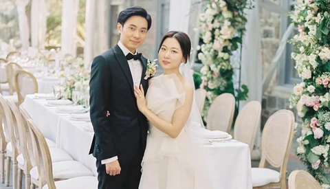 Bride and groom posing together at an elegant reception venue with floral installations.