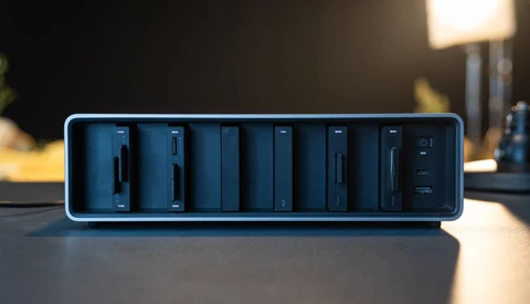 Blue-rimmed modular charging dock with eight vertical slots containing dark charging modules.
