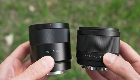 Two Sony prime lenses held side by side: FE 1.8/55 and AF 50/2.0 FE, showing barrel designs and aperture markings.