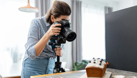 Female photographer shooting video with a professional camera mounted on a gimbal stabilizer.