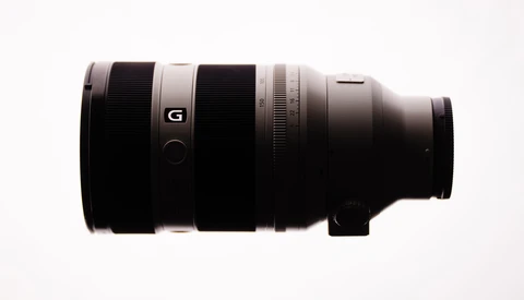 Sony G-series telephoto lens with black barrel and white accent ring on neutral background.