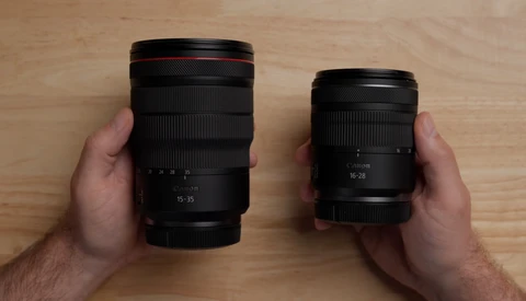 Two camera lenses held in hands side by side for comparison, showing different sizes and focal length ranges.